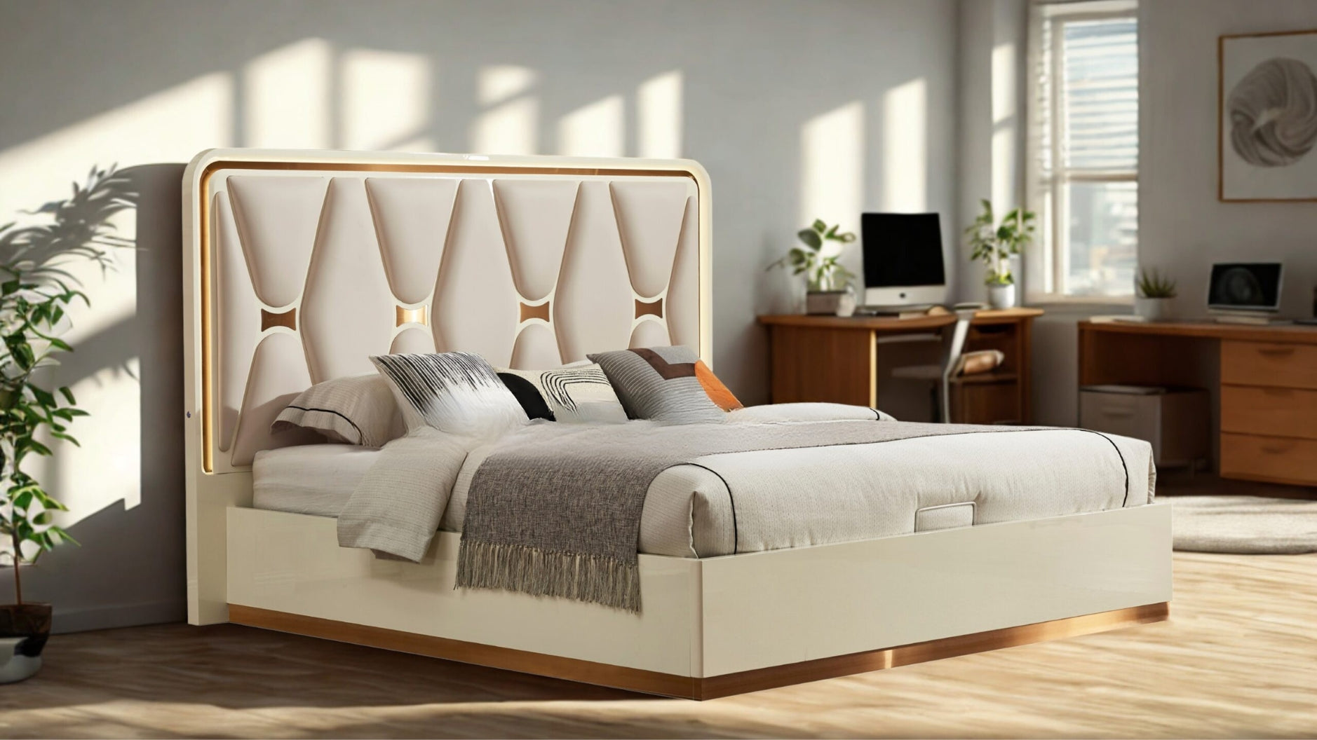 Beige upholstered bed in a bright bedroom with wooden desk and computer.