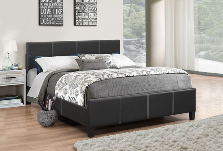 Bedroom with a black upholstered bed and decorative pillows.